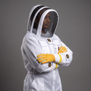White suit woman fencing veil arms crossed studio dark